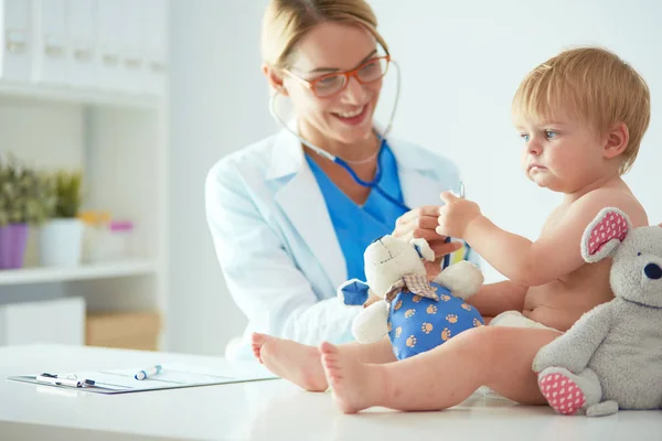 Жінка-лікар слухає дитину зі стетоскопом у клініці — стокове фото
