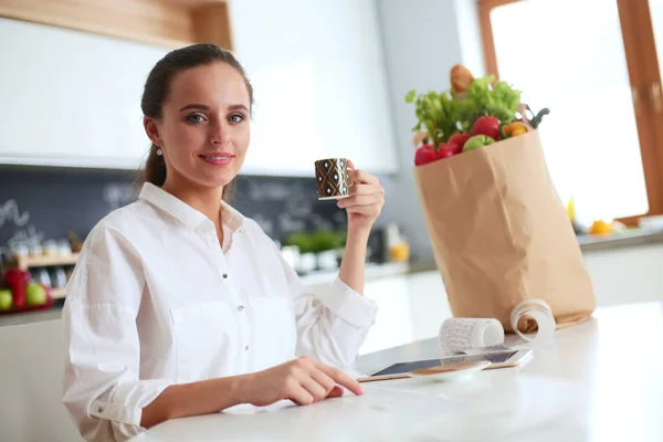 Joven mujer planeando gastos y pagando facturas en su cocina . —  Fotos de Stock
