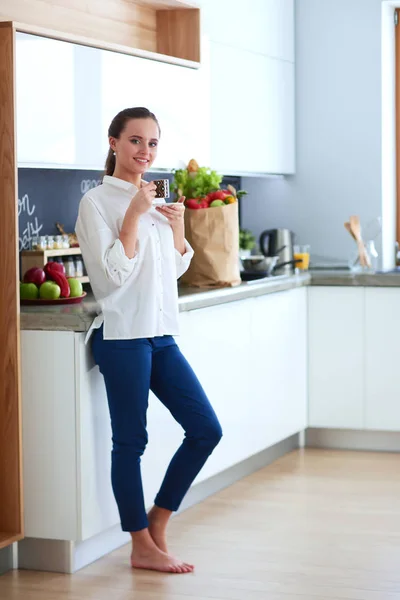 Jonge vrouw planning van kosten en betalen van rekeningen op haar keuken. — Stockfoto