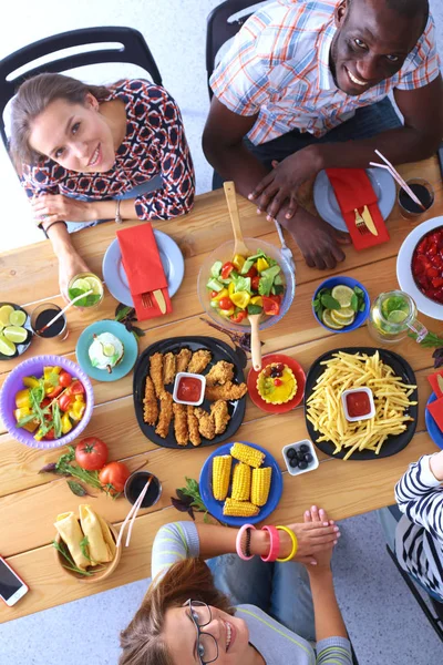 Drei Frauen sitzen zusammen an einem Schreibtisch. Essen auf den Tisch. Menschen essen Fast Food. — Stockfoto