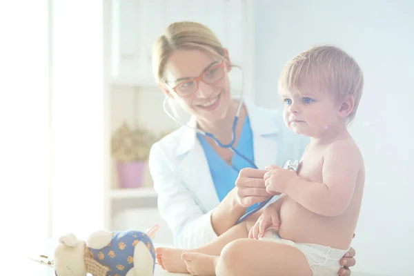 Vrouwelijke arts luistert kind met een stethoscoop in de kliniek — Stockfoto