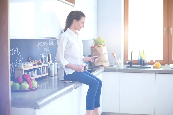 Retrato de mujer joven de pie sobre el fondo de la cocina . — Foto de Stock