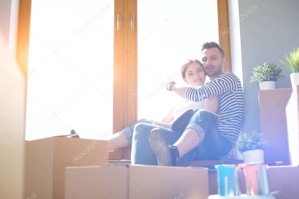 Couple moving in house sitting on the windowsill. Couple