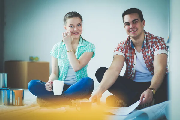 Casal jovem sentado no chão e calculando sobre eles economia. Casal jovem — Fotografia de Stock