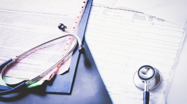 Masadaki elektrokardiyogramda tıbbi stetoskop.