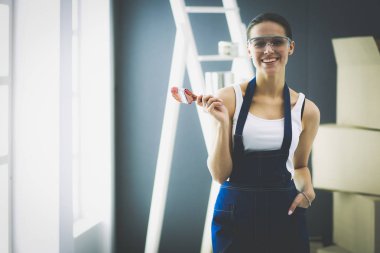 Güzel genç bir kadın duvar boyuyor..