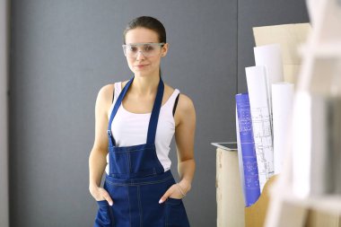 Güzel genç bir kadın duvar boyuyor.