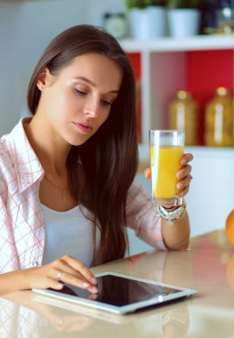 Mutfakta ipad 'ini kullanan genç bir kadın. Genç kadın.