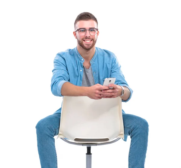 Young man sitting on chair and using mobile phone. Startupper. Young entrepreneur. — Stock Photo, Image