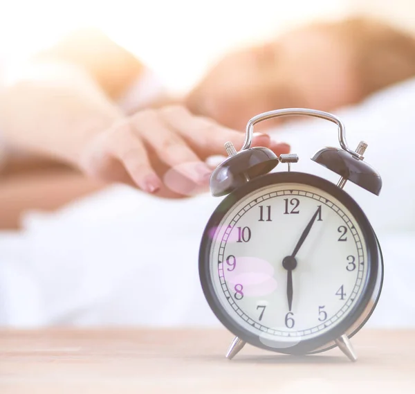 Young sleeping woman and alarm clock in bedroom at home — Stock Photo, Image