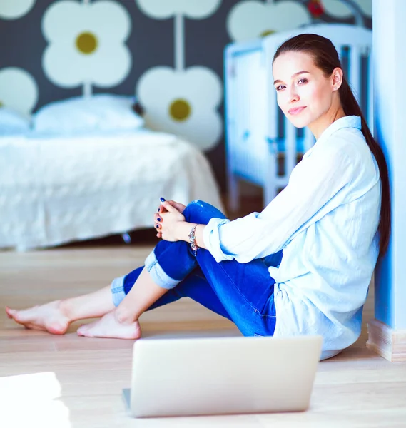 Jonge mooie vrouw thuis zittend op de vloer met laptop — Stockfoto