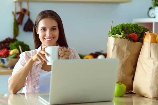 Smiling woman online shopping using tablet and credit card in kitchen . Smiling woman — Stock Photo, Image