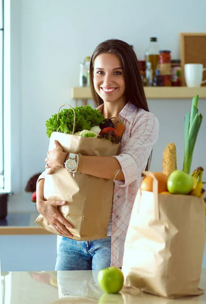 Молода жінка тримає продуктовий сумку з овочами. Молода жінка — стокове фото