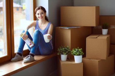 Kadın seçerek boya rengi renk örneği yeni ev ahşap yere oturmak için. Kadın evde