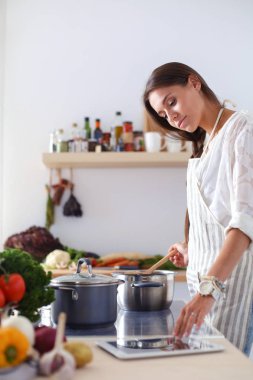 Mutfakta ahşap kaşıkla yemek pişiren kadın. Aşçı kadın.