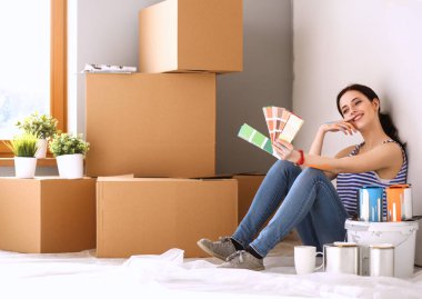 Kadın seçerek boya rengi renk örneği yeni ev ahşap yere oturmak için. Kadın evde