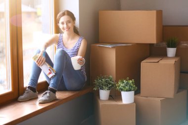 Karton kutularla dolu yeni bir evde bir kadın. Evdeki kadın..