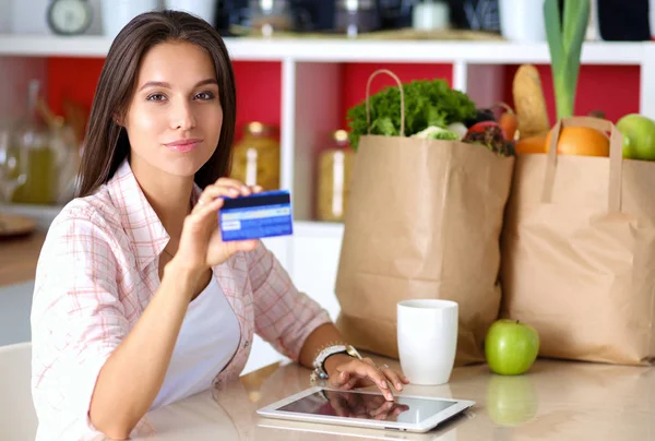 Young woman in the kitchen, using her ipad. Young woman — Stock Photo, Image