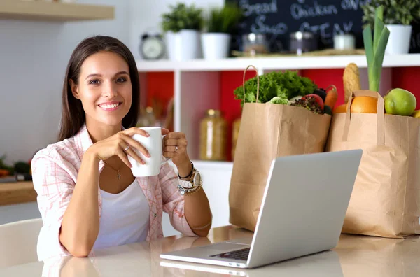 Wanita tersenyum online belanja menggunakan tablet dan kartu kredit di dapur. Wanita tersenyum. — Stok Foto