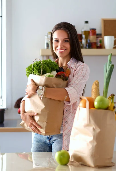 Egy fiatal nő zöldséges bevásárlószatyrot tart a kezében. Fiatal nő — Stock Fotó