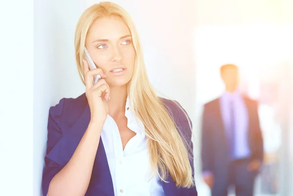 Zakenvrouw staat tegen het raam te praten op de mobiele telefoon. Zakenvrouw — Stockfoto