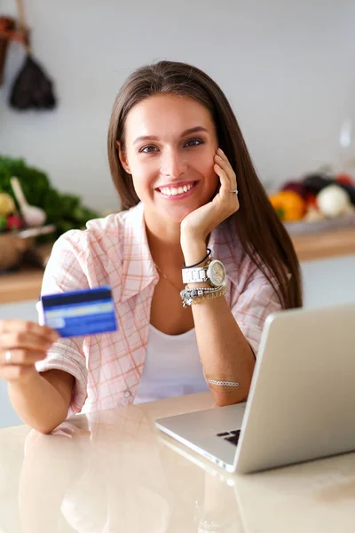 在厨房用平板电脑和信用卡给网上购物的女人微笑。微笑的女人 — 图库照片#