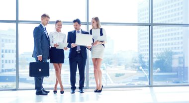 Grup iş adamları toplantı sırasında dizüstü bilgisayar ile sunum yapıyor. Grup iş adamları