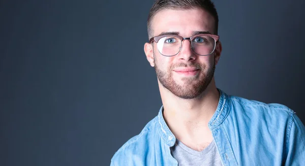 Retrato de un hombre casual feliz de pie aislado sobre un fondo oscuro — Foto de Stock