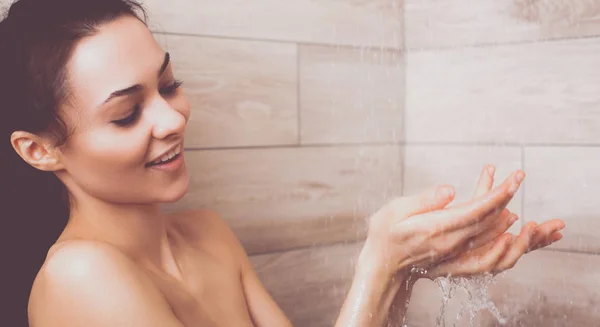 Joven mujer hermosa bajo la ducha en el baño . — Foto de Stock