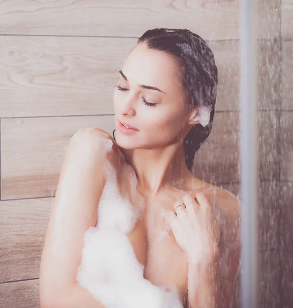 Joven mujer hermosa bajo la ducha en el baño . — Foto de Stock