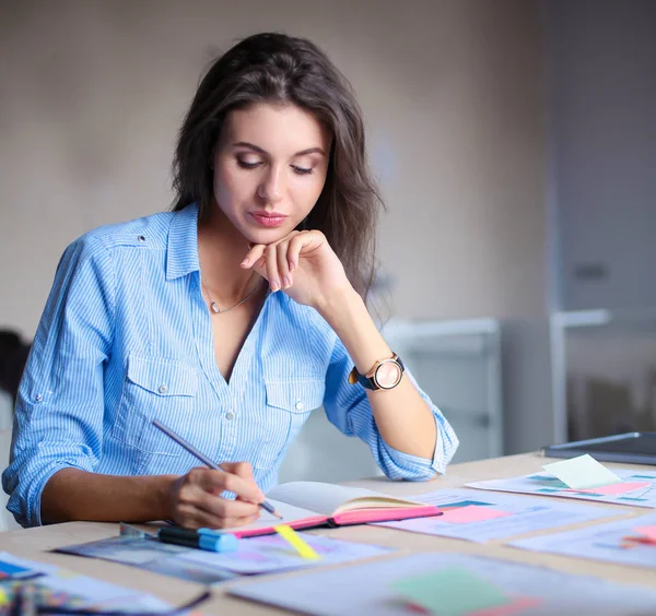 Jovem sentada à mesa do escritório. Jovem mulher . — Fotografia de Stock