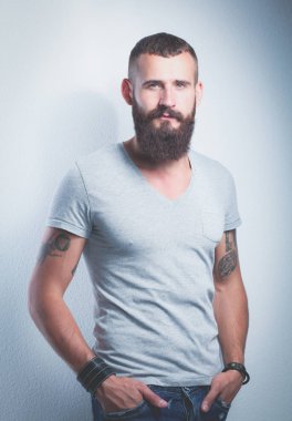 Ayakta, gri arka plan üzerinde izole yakışıklı adam portresi