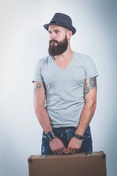 Portrait of handsome bearded man in hat standing with bag, isolated on white background — Stock Photo, Image