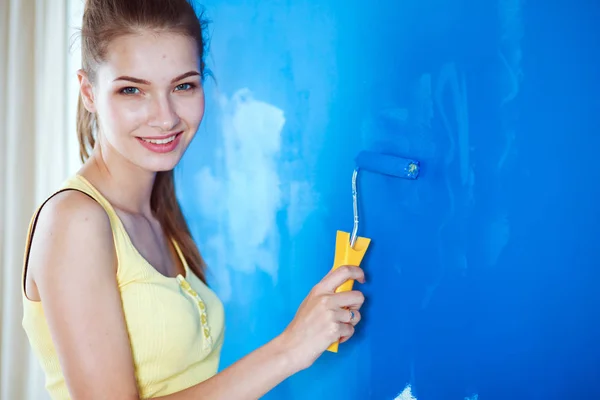 Joyeux belle jeune femme faisant de la peinture murale, debout près de l'échelle — Photo