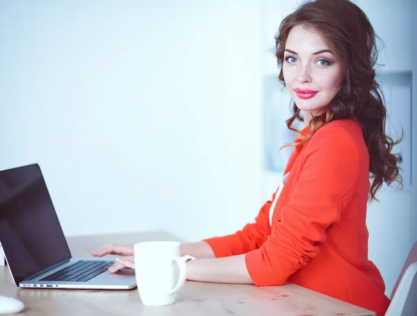 Belle femme assise au bureau, travaillant avec un ordinateur portable — Photo