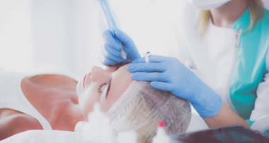 Kaşlar için kalıcı makyaj. Güzellik salonunda kalın kaşlı güzel bir kadın.