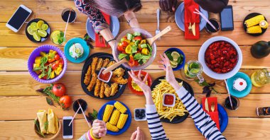 Yemek masasında içki içen insanlar.