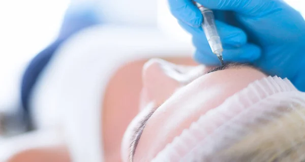 Maquillaje permanente para cejas. Primer plano de mujer hermosa con cejas gruesas en salón de belleza —  Fotos de Stock