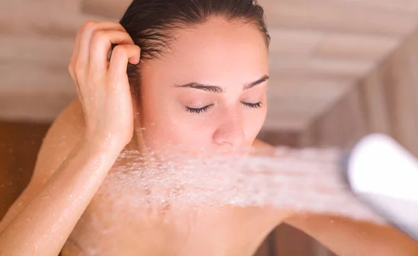 Joven mujer hermosa bajo la ducha en el baño . — Foto de Stock