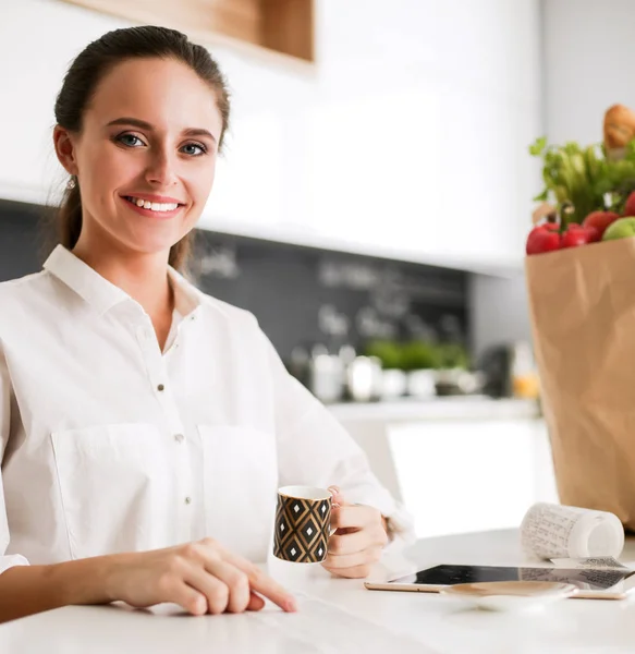 Jonge vrouw planning van kosten en betalen van rekeningen op haar keuken. — Stockfoto