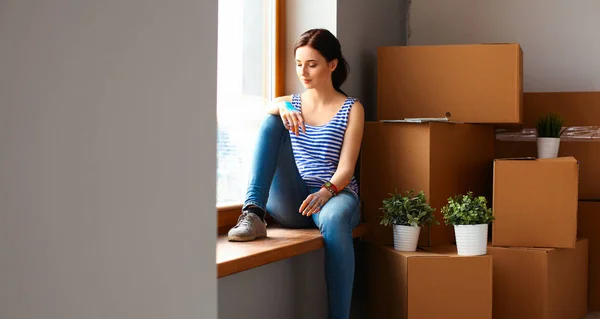 Девушка сидит на подоконнике в новом доме с чашкой — стоковое фото