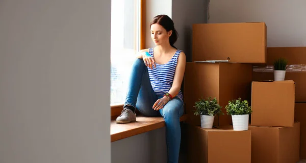 Girl sitting on windowsill at new home with cup — Stock Photo, Image