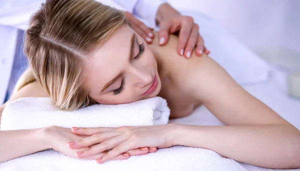 Jovem deitada em uma mesa de massagem, relaxando com os olhos fechados. Mulher. Salão de Spa — Fotografia de Stock