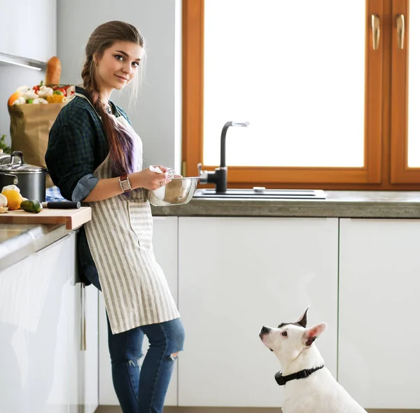 Porträtt av ung kvinna som står mot kök bakgrund. — Stockfoto
