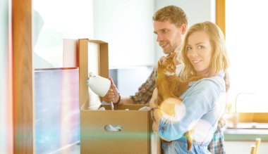 Genç bir çift yeni evde büyük karton kutu taşıyan. Ev taşıma. Genç Çift