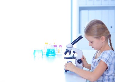 kız öğrenci fen bilgisi dersinde mikroskop aramak.