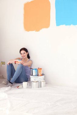 Kadın seçerek boya rengi renk örneği yeni ev ahşap yere oturmak için. Kadın evde