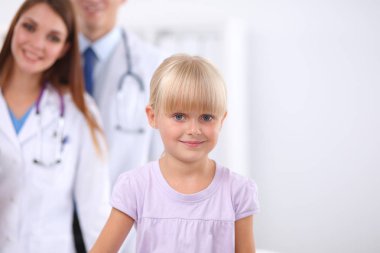 Kadın doktor ameliyatta steteskopla çocuğu muayene ediyor.