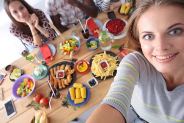 Öğle yemeği sırasında selfie çeken bir grup insan. Kendim. Arkadaşız. Arkadaşlar yemek yerken fotoğraflanır.