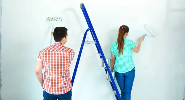 새 집의 행복 한 미소 젊은 부부 그림 인테리어 벽의 초상화 — 스톡 사진